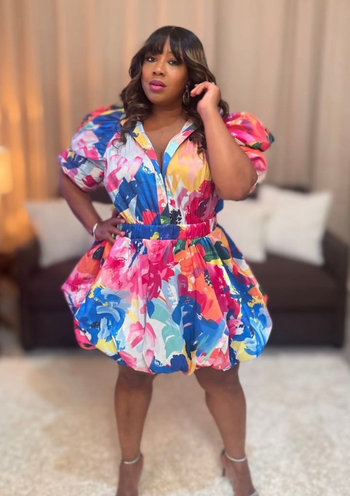 Woman wearing a colorful floral dress in an indoor setting