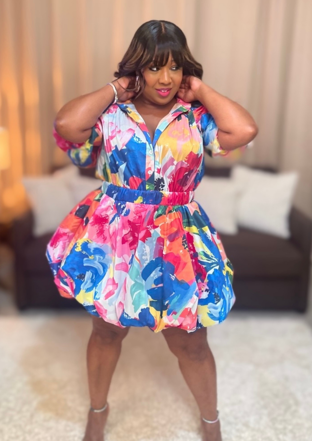 Woman wearing a colorful floral dress in an indoor setting