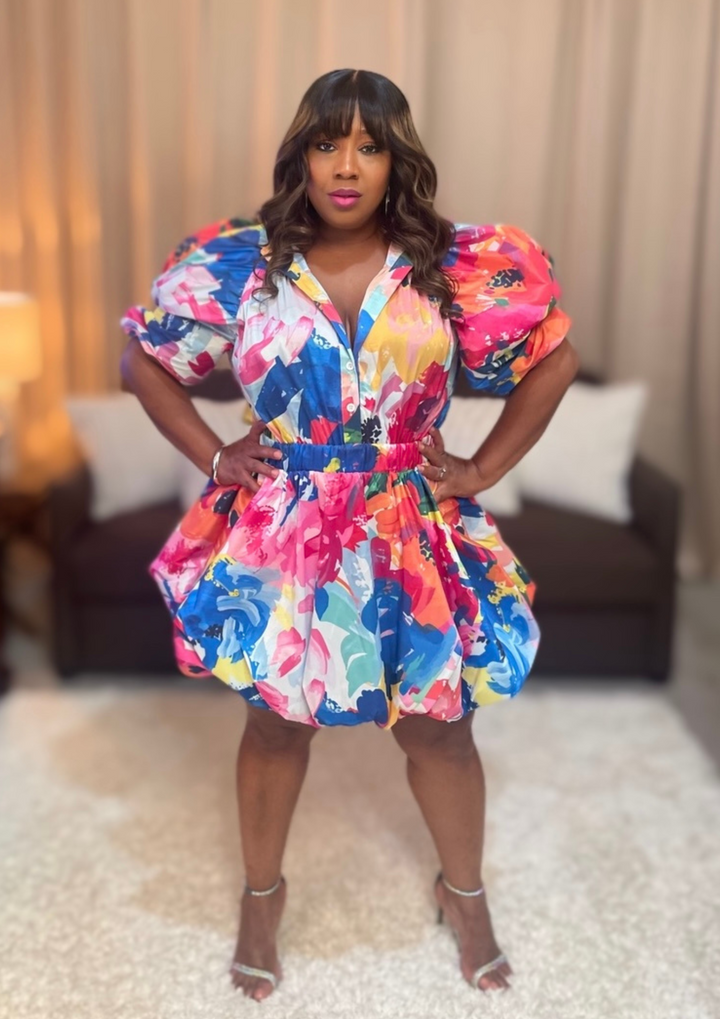 Woman wearing a colorful floral dress in an indoor setting